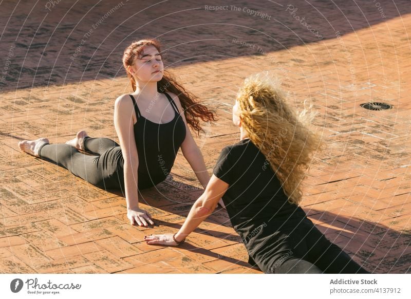 Flexible women practicing yoga back bend asana on terrace together practice pose position cobra bhujangasana prone flexible balance stretch acro yoga partner