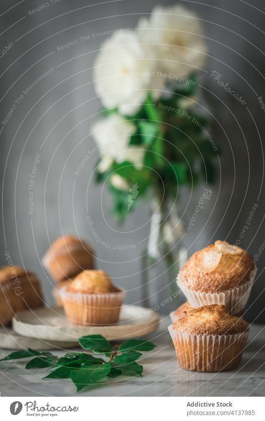 Delicious cupcakes in composition with bouquet of fragrant white flowers in vase on table food treat rose meal dessert pastry leaf fresh nutrition bloom