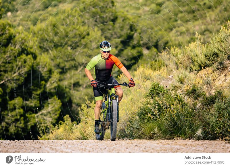 Man in helmet riding mountain bike in forest man bicycle ride stone autumn extreme sport nature adrenaline lifestyle countryside adventure activity healthy