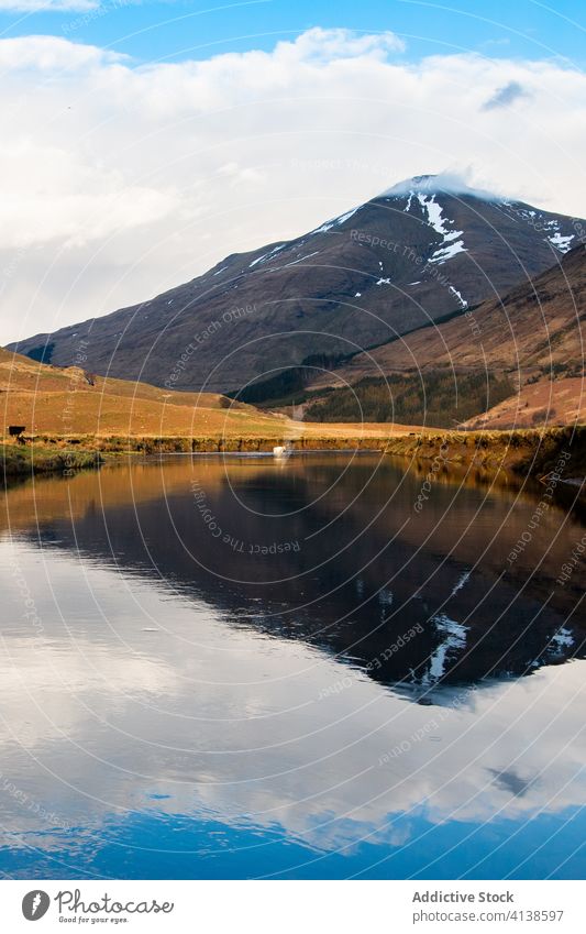 Cloudy sky and mountain reflected in lake reflection landscape calm peak nature scotland highland glen coe water scenery scenic environment peaceful wild serene