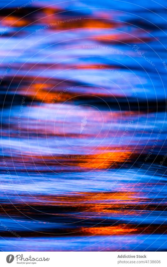 Light reflected in dark water light reflection ripple texture sunset dusk background nature night glow shiny illuminate abstract bright beam surface colorful