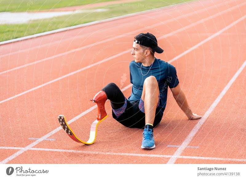 Disabled Man Athlete Resting portrait front view resting sitting stadium running track man runner athlete sport prosthesis prosthetic disability disabled