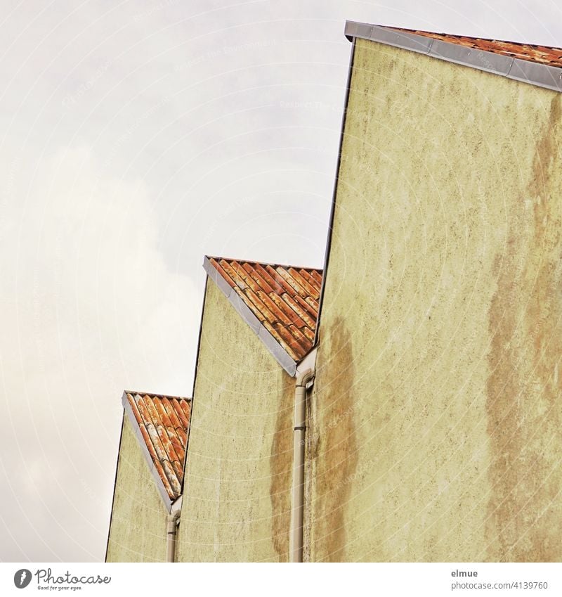 Side view of an old, well-preserved factory building with a shed roof and downpipes between the individual gable roofs / sawtooth roof Shed roof Gable roof