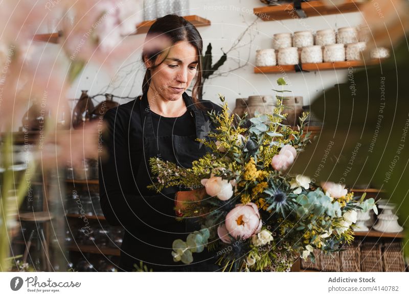 Female designer creating floral bouquets in studio floristry woman arrange create bloom blossom compose decorative female creative work occupation professional