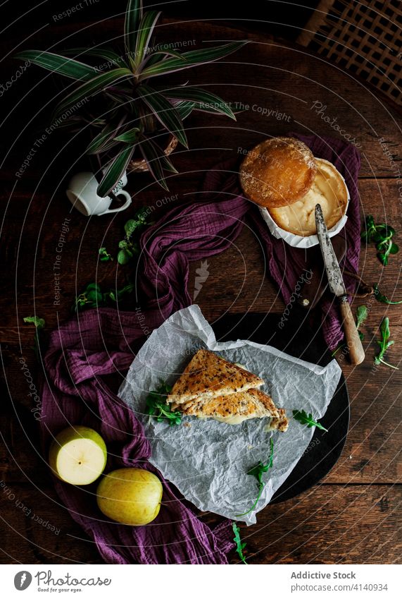 Sandwich and baked Camembert cheese on kitchen table omelet camembert sandwich white mould cheese bread toast delicious serve plate ingredient healthy fruit