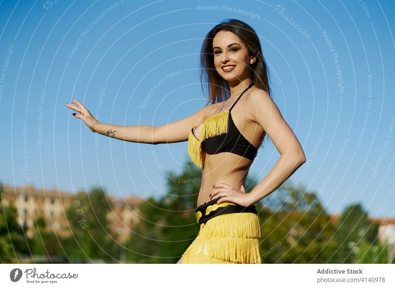 Slim ethnic woman in costume dancing in city belly dance posture dancer oriental tradition practice energy talent female grace smile pose flexible elegant move