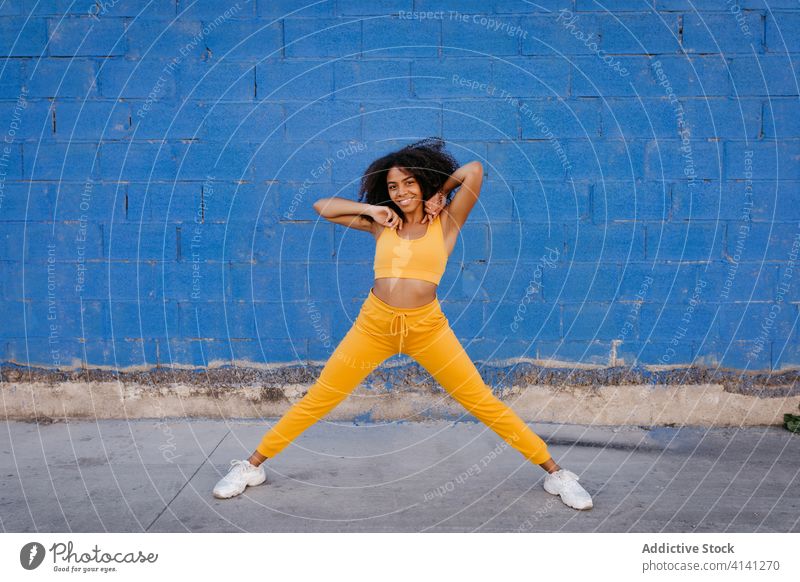 Cheerful African American woman with afro hairstyle in dancing pose dance move vivid vibrant cheerful smile motion color female black ethnic african american