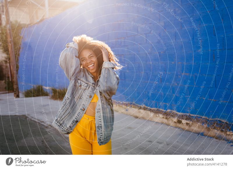 Cheerful woman smiling and grimacing on street smile cheerful grimace afro denim millennial city vivid bright female black african american ethnic vibrant color