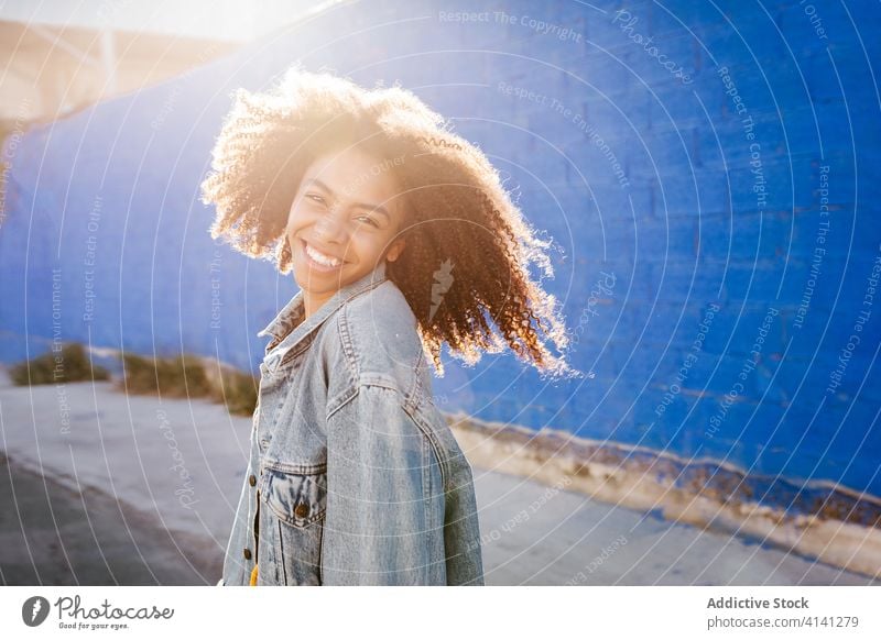 Cheerful woman smiling and grimacing on street smile cheerful grimace afro denim millennial city vivid bright female black african american ethnic vibrant color