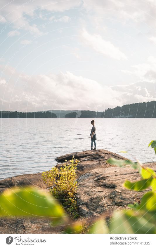 Lonely traveler standing on lake shore man stone nature freedom harmony landscape enjoy male water rock journey tourism adventure algonquin provincial park