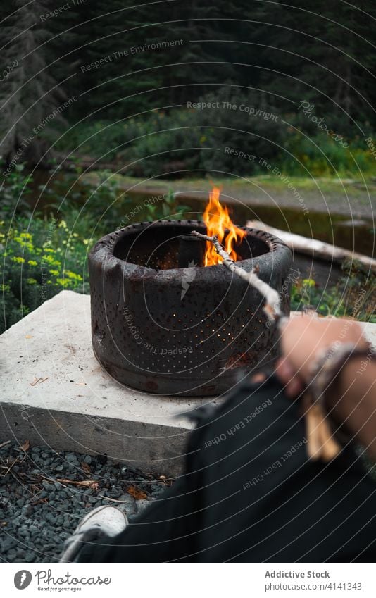 Crop traveler near campfire in metal ring rural leisure woods forest new brunswick canada tourist bonfire holiday nature tranquil countryside active idyllic