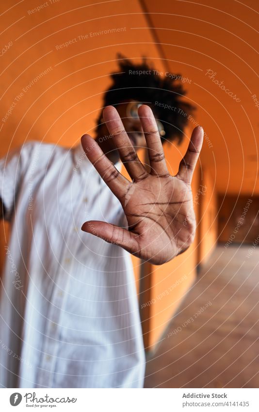 Serious black woman with hands raised protesting and trying to stop violence prevent against gesture sign dissuade objection concept renouncement refuse serious