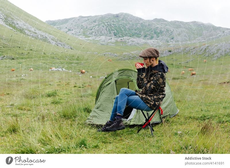 Woman in outerwear near camping tent in nature woman highland content relax traveler morning wanderlust freedom landscape harmony joy casual countryside cold