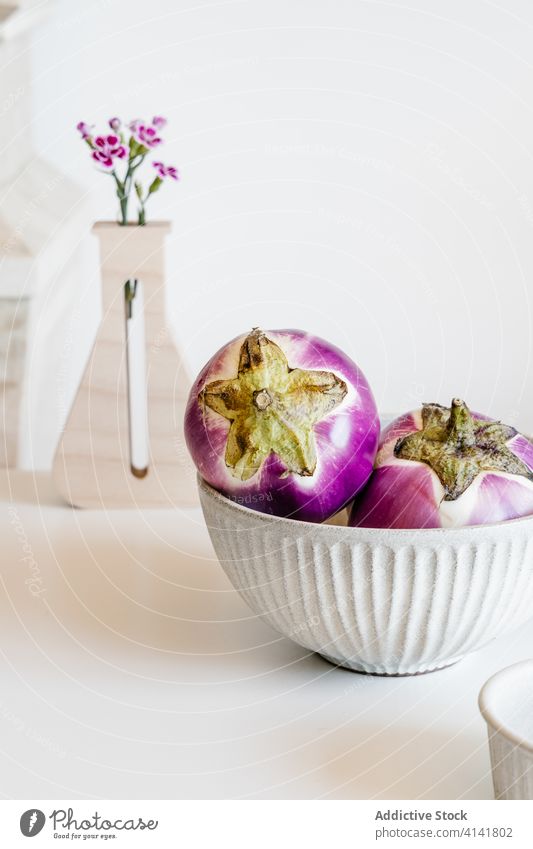 Tasty eggplants in bowl on table vegetable fresh ripe kitchen food organic healthy food modern flower decor vase gourmet tasty vegan diet ingredient home