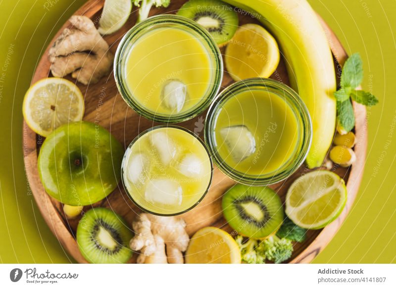 Delicious detox cocktails on tray with lemon and kiwi slices drink beverage juice antioxidant healthy ingredient fruit organic refreshment wooden cube ginger