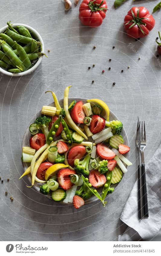 Set of fresh berries and vegetables on plate various assorted healthy tasty healthy food set gourmet tomato strawberry cucumber lemon citrus green bean pea