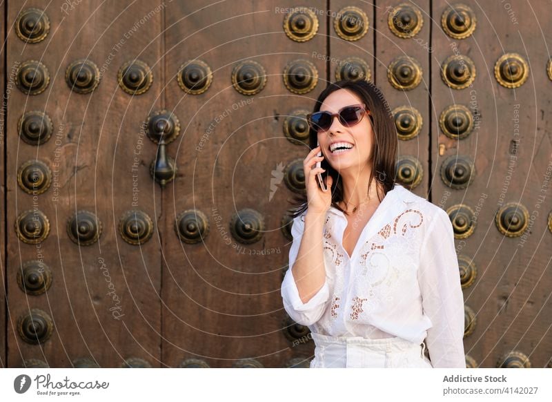 Confident woman using smartphone in city read message summer speak confident stroll street female calm building style rest town relax weekend gadget device