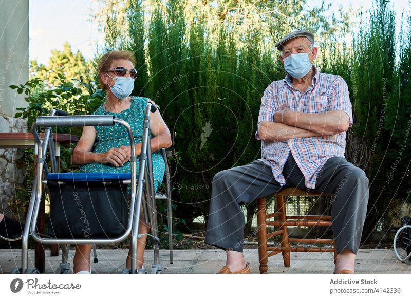 Group of senior people sitting on terrace of house elderly grandparent gather yard together old mask coronavirus protect covid pandemic lifestyle aged