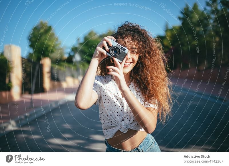 Happy woman taking photo on camera outside take photo photo camera digital moment sunshine cheerful using device hobby toothy smile happy professional joy