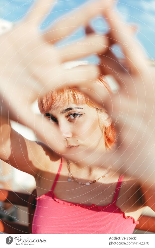 Young woman with pink hair in city millennial carefree different behavior expressive cityscape grimace female creative modern trendy gesture style fun childish