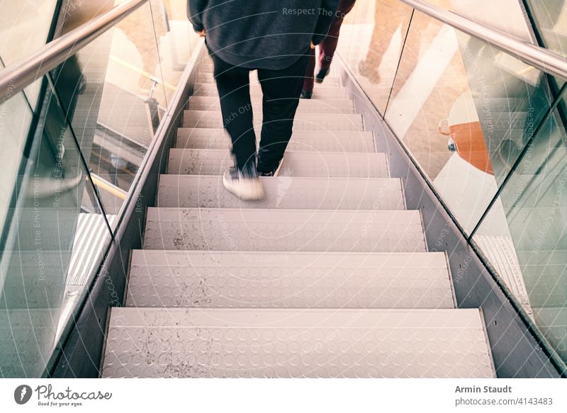 blurred legs of a person go down a staircase background building city concept dirty fast glass goal grunge hurry job lifestyle male man maze metal mirroring