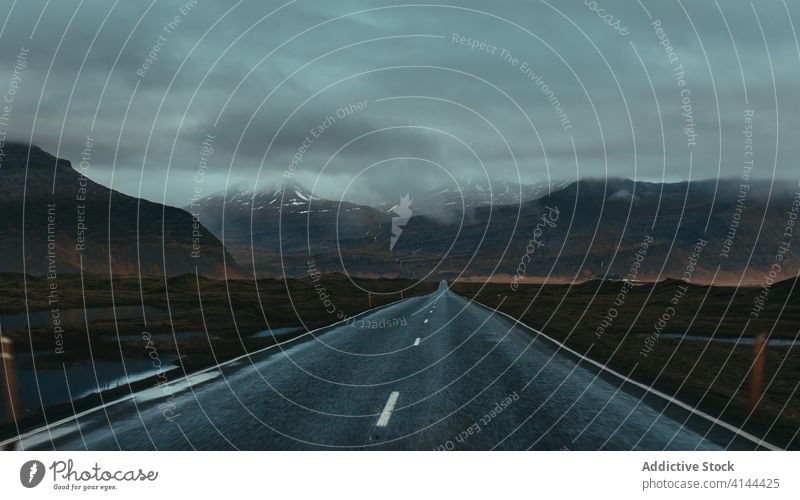 Breathtaking view of road near mountains under cloudy sky landscape empty highland straight idyllic scenery narrow abandoned natural tranquil silent ridge