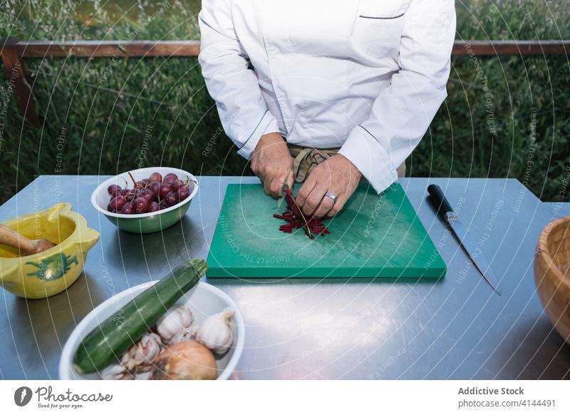 Male cook cutting vegetables for dinner preparation in outdoor kitchen man beet chef prepare dish fresh healthy food work cuisine male middle age uniform