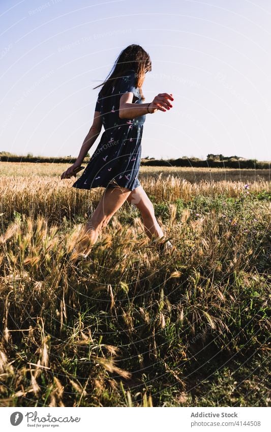 Cheerful woman walking along field run countryside carefree weekend summer sunny freedom cheerful female rubber boot dress joy meadow nature harmony idyllic