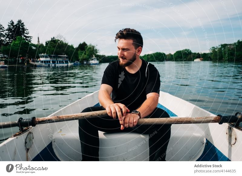 Content man rowing boat on peaceful pond lake positive oar nature activity content picturesque calm relax summer leisure saint george transylvania romania quiet