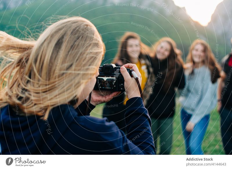 Woman taking photo of friends in mountains vacation together unity company highland take photo travel moment transylvania romania saint george group happy green