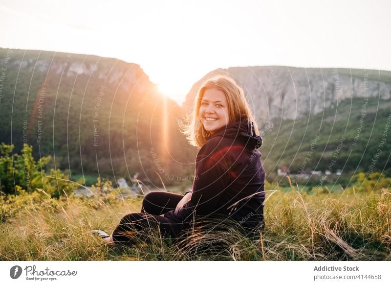 Traveling woman sitting in mountains tourist vacation relax highland female transylvania romania saint george sunset travel rest grass lady summer camera