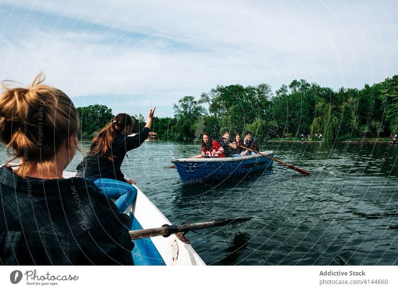 Group of people on boats chatting while floating on river friend gesticulate positive nature activity picturesque arm raised carefree together beautiful rowing