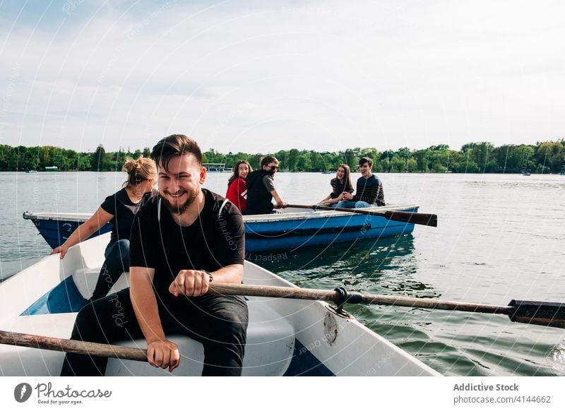 Happy friends having fun on boats and using smartphone pond laugh happy positive nature friendship activity picturesque browsing young chill cheerful carefree