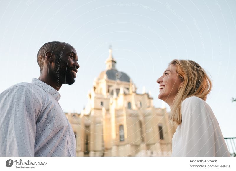 Cheerful diverse couple laughing on street cheerful carefree toothy smile relationship candid content madrid spain love casual positive lifestyle beautiful