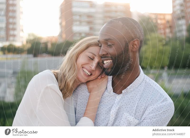 Tender multiracial couple hugging each other lovingly bonding rest in love romantic content tender sensual eyes closed cuddle happy cheerful fondness affection