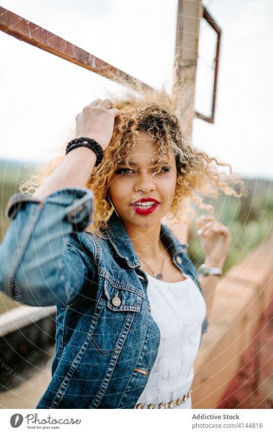 Stylish ethnic woman on old bridge style grunge trendy fashion shabby railing confident female african american black charming smile content calm joy positive