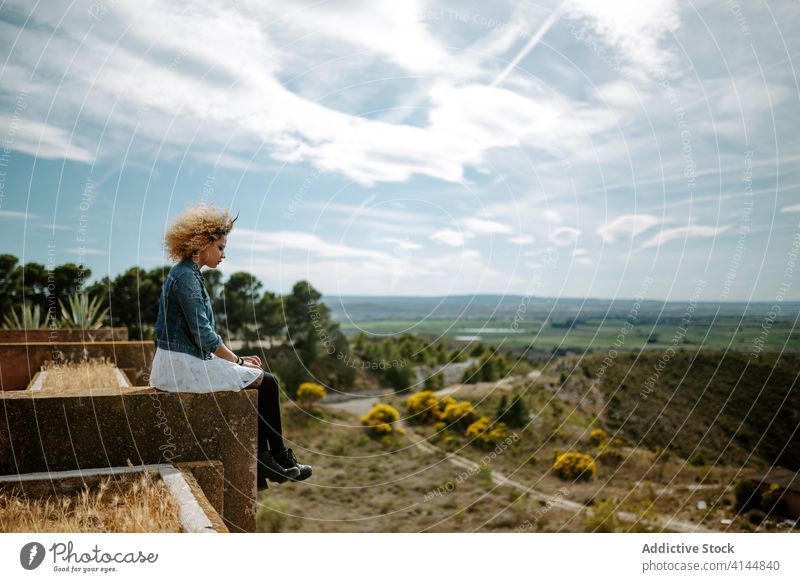 Woman relaxing on rooftop on sunny day building old woman amazing landscape admire edge rest female ethnic african american black curly hair enjoy journey