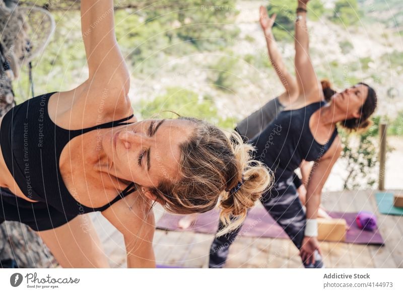 Group of female yoga student doing Side Angle asana in park women side angle parsvakonasana class healthy balance stretch exercise active practice position