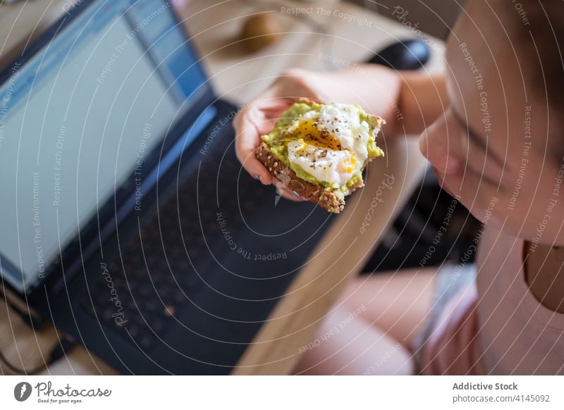 Ethnic woman eating breakfast on bed toast avocado egg delicious healthy nutrition morning ethnic asian cozy home food relax comfort tasty meal fresh rest sit