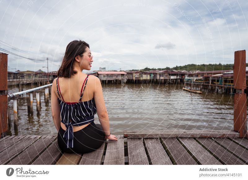 Asian female traveler on wooden pier woman kampong ayer village float famous landmark lake asian ethnic bandar seri begawan brunei borneo quay tourist joy happy