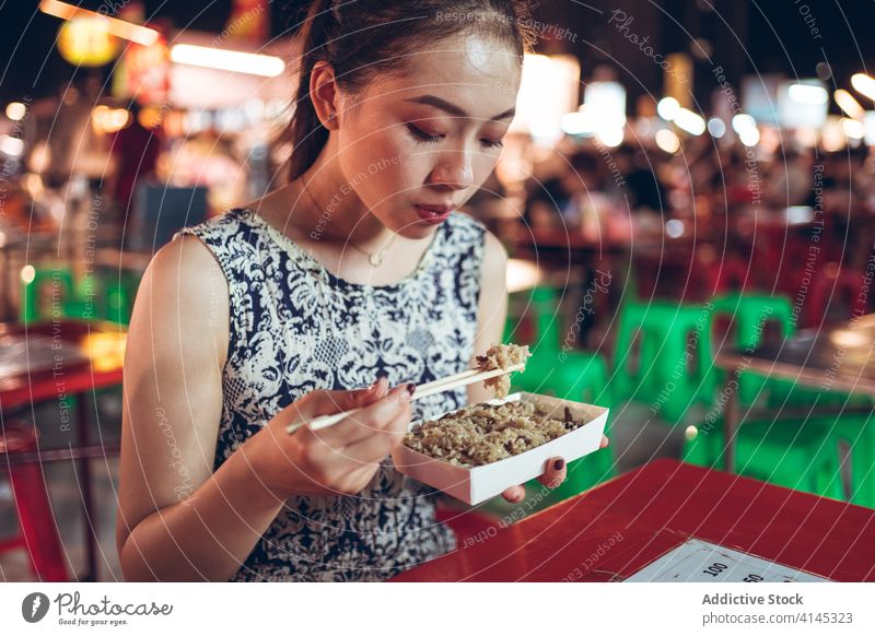 Asian woman eating rice in Zhubei Night Market glutinous oil rice dish oriental zhubei night market delicious tradition street food chopstick female taiwan