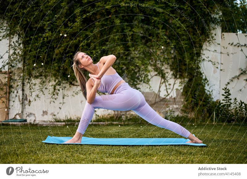 Calm woman doing yoga in Parivrtta Anjaneyasana parivrtta anjaneyasana pose revolved crescent lunge namaste gesture calm flexible female sportswear practice