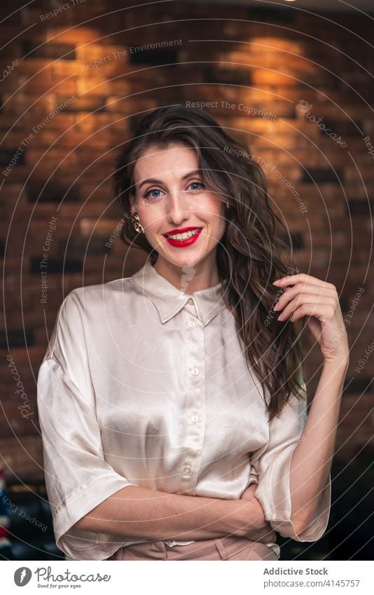 Elegant smiling woman in loft room style confident young elegant chair positive portrait modern charming smile pleasant female trendy calm friendly long hair