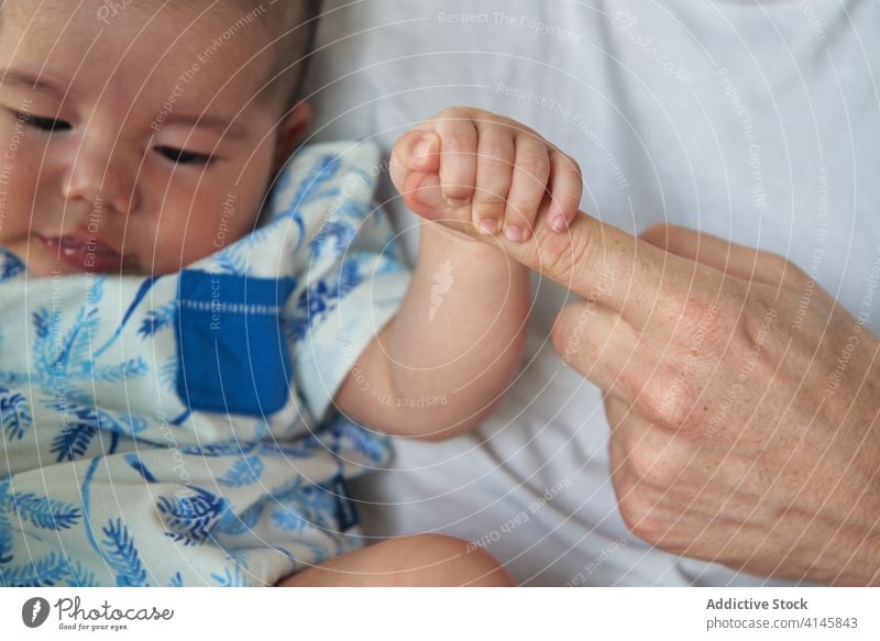 Baby holding his father's hand family baby child boy dad mom mother fun enjoy home at home stay at home beautiful model portrait flat people happy family