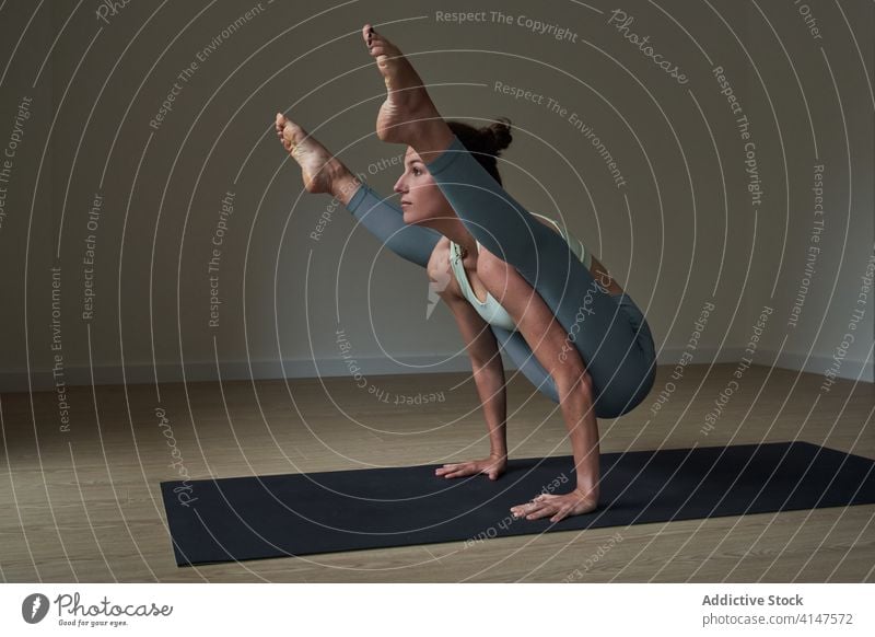 Cheerful sportswoman improving concentration while doing Tittibhasana yoga pose practice ashtanga vinyasa firefly happy strong athlete smile balance exercise