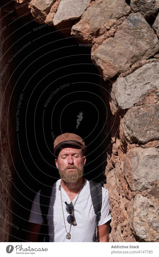 Male tourist visiting historic stone building traveler hipster man old ancient arch archway doorway architecture trip sightseeing explore heritage antique