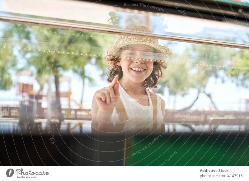 Smiling boy making choice in shop with glass showcase delight joy content retail customer buy point window store choose shopper sale purchase commerce consume