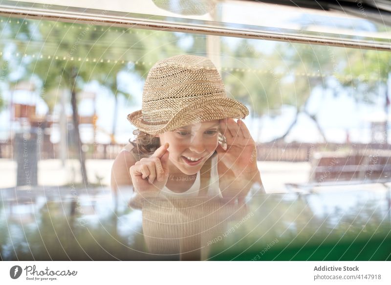 Smiling boy making choice in shop with glass showcase delight joy content retail customer buy point window store choose shopper sale purchase commerce consume