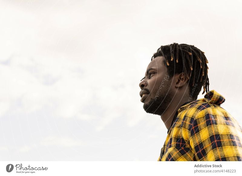 profile of a black with the sky in the background african person portrait young american man male handsome guy looking attractive afro ethnicity confident