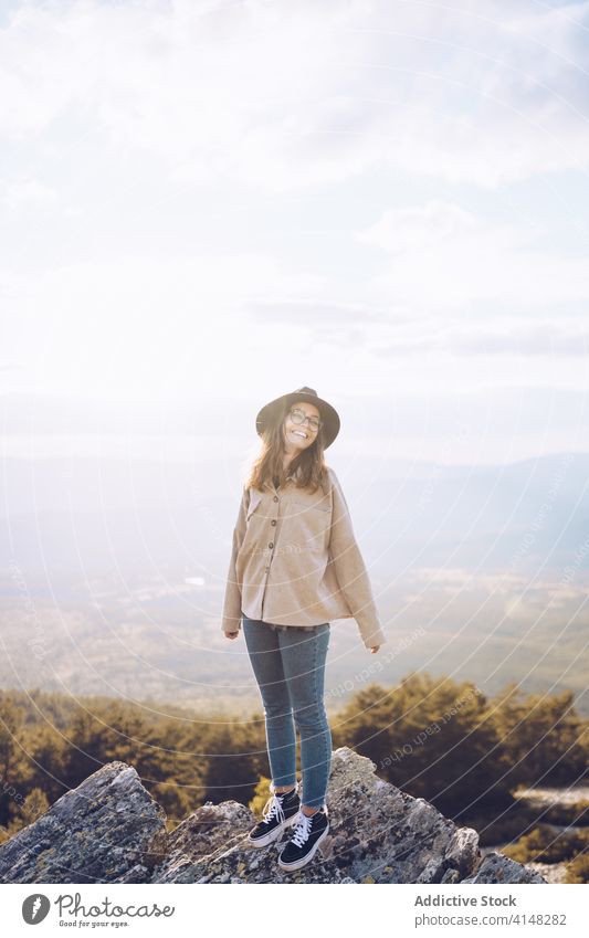 Tranquil woman on the rock during vacation traveler mountain enjoy landscape admire highland amazing hill sunlight female carefree trip adventure valley sunny